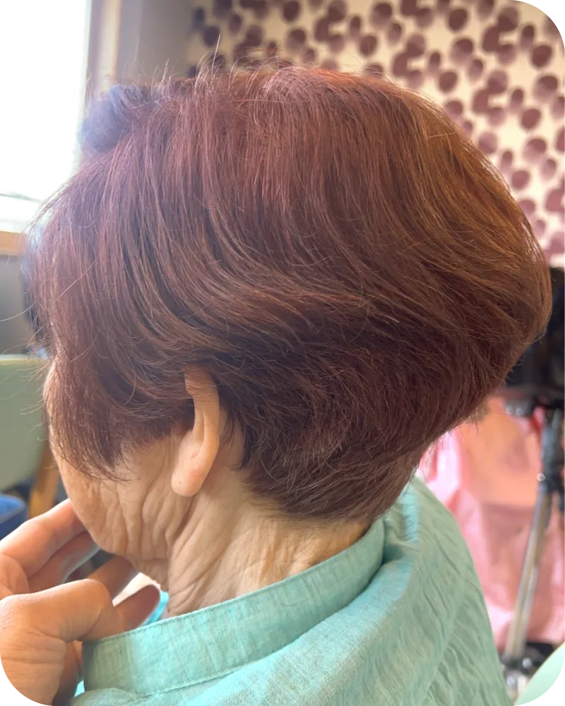カラーで仕上げた赤褐色のショートヘアを見せる高齢の利用者